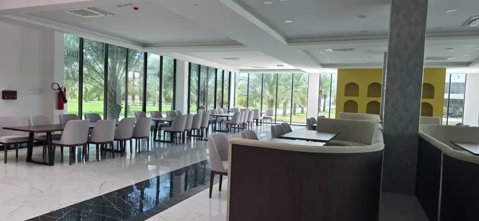 Tables along the glass wall, looking onto the palms